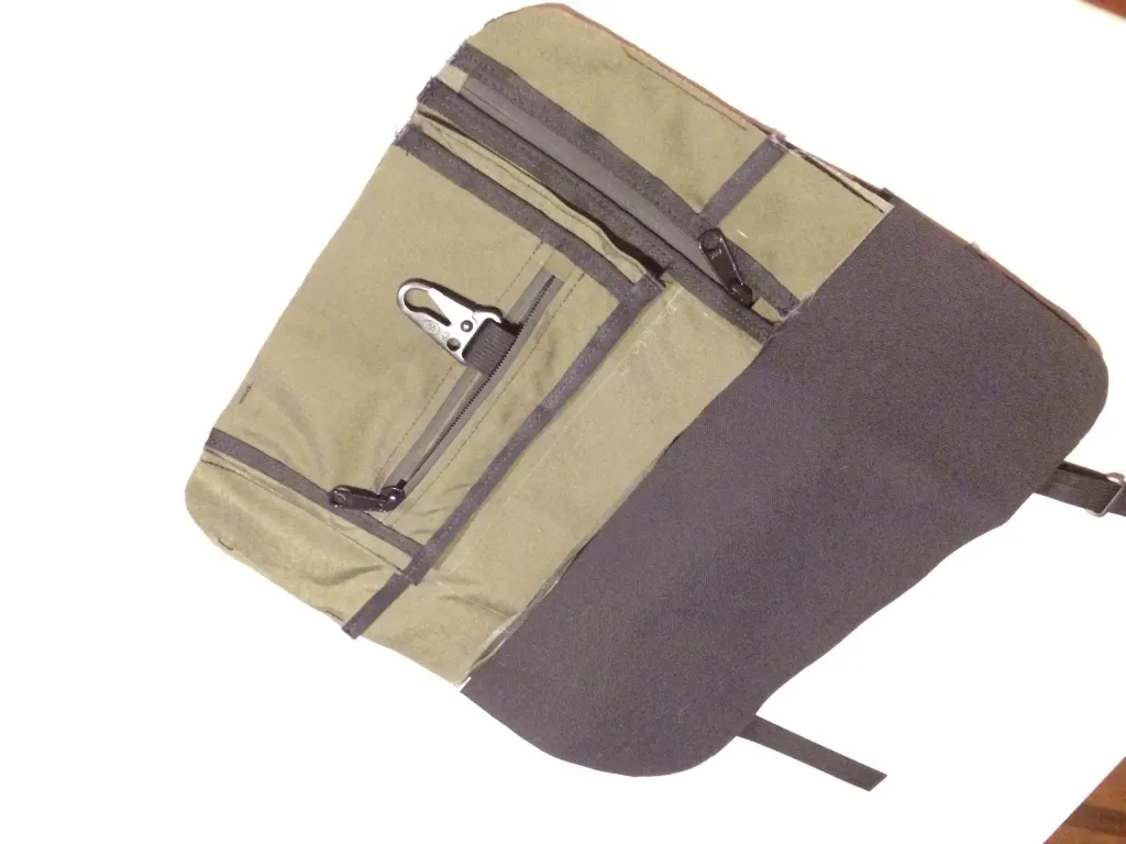 An early olive prototype with gray flaps, zippered pockets and a metal clip
