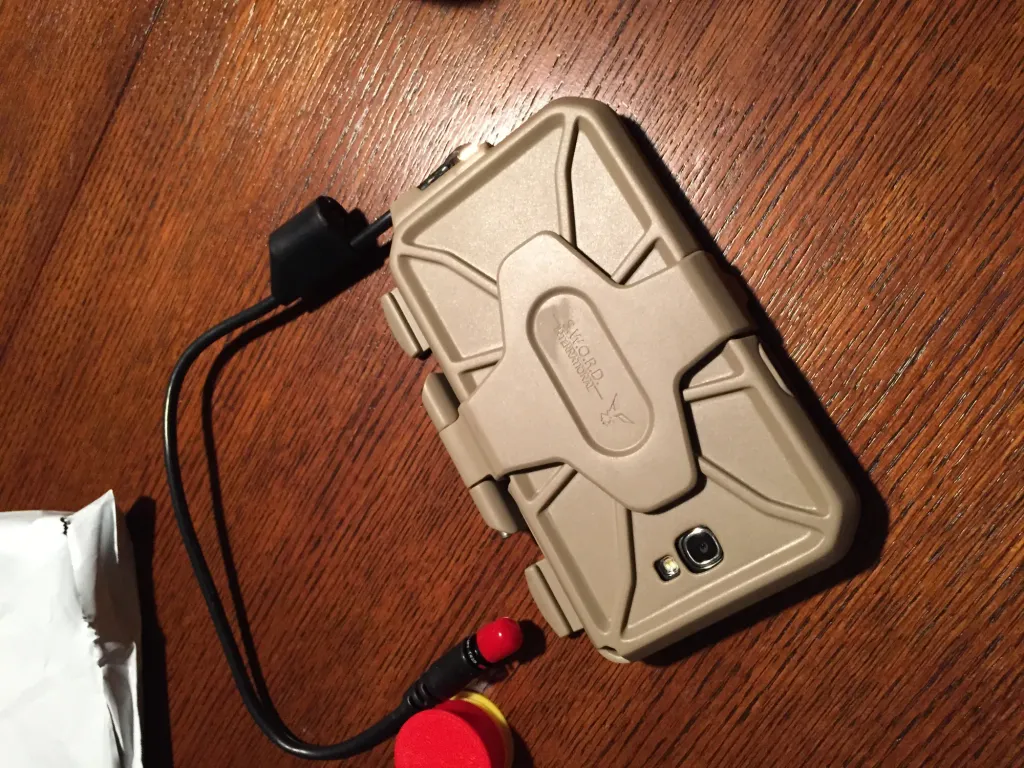 Tan case on a wooden table, with its cable running to a connector