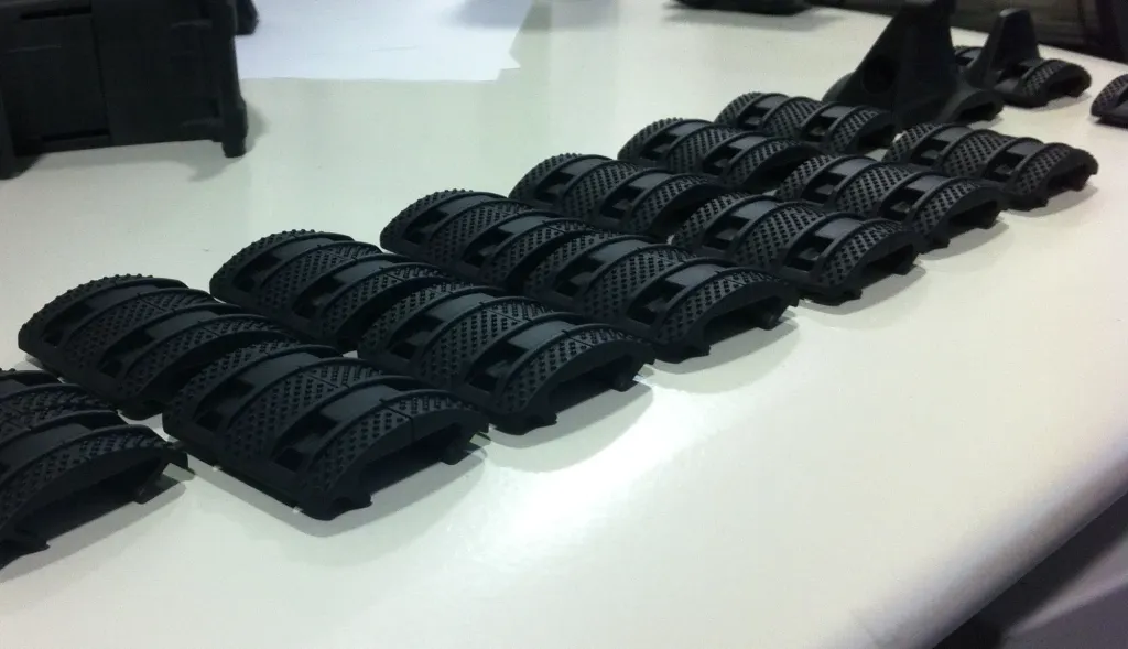 Rows of molded black Enhanced rail panels and two hand stops lined up on a desk