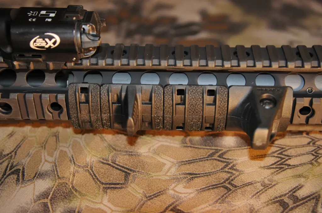 XTM Hand Stop Kit installed on the lower rail of a rifle handguard, behind a weapon light